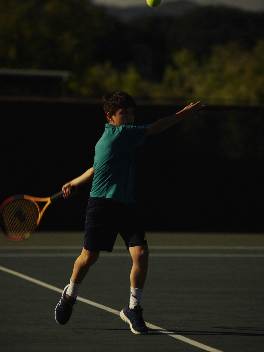 Junior tennis player mid-swing during a private lesson in North County San Diego